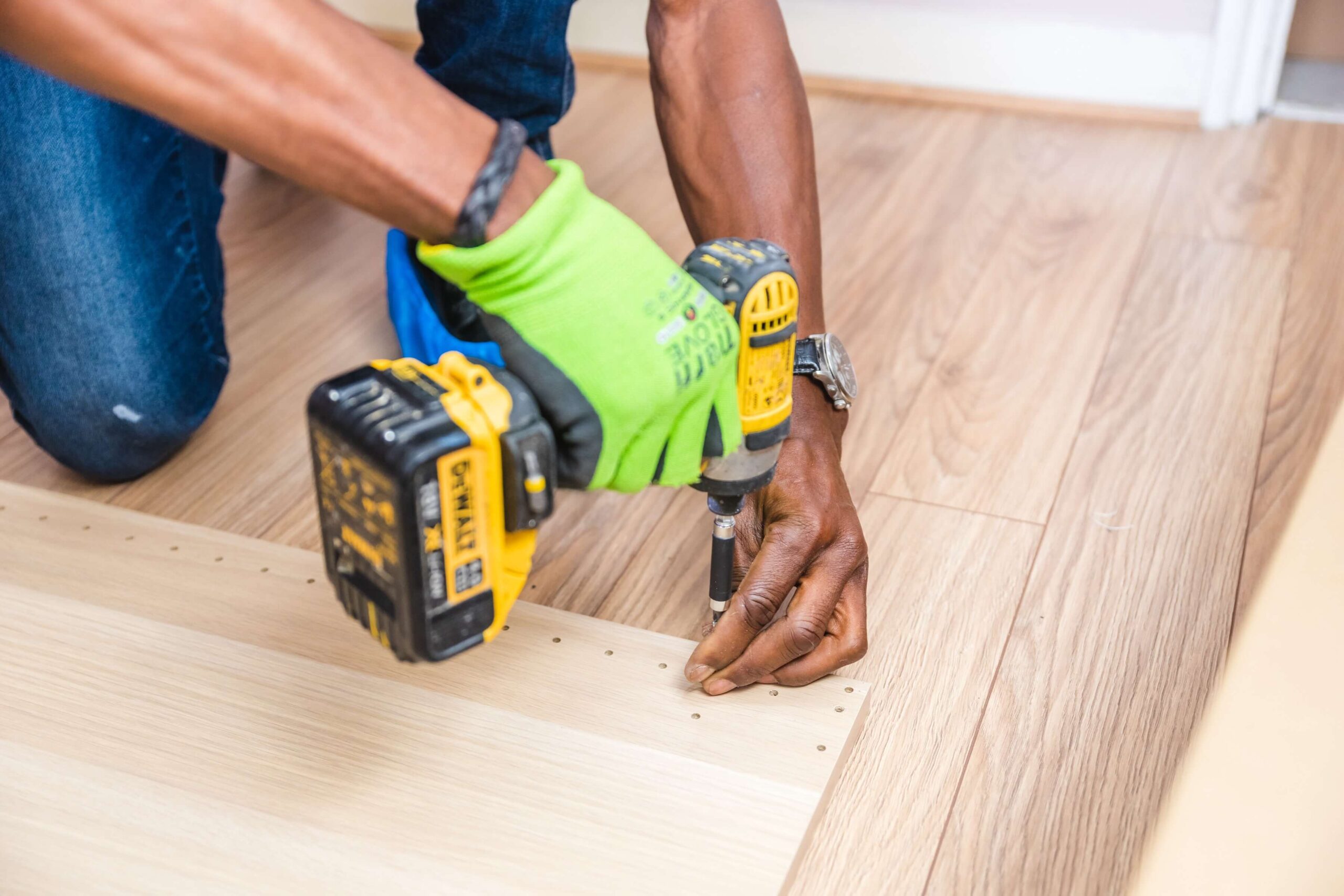 Man using a drill on a wood plank.